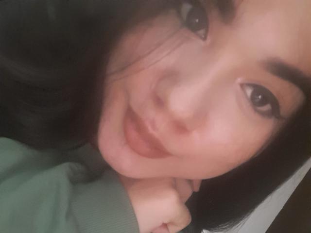 SteffanyTaylor's face, showing a slight smile with dark eyebrows, black hair, and wearing a green shirt, has her hand near her chin in a selfie.