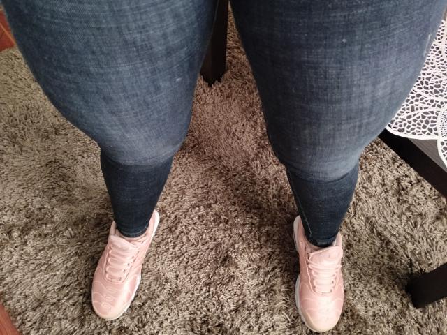 LuluFrancaise's ass in tight blue jeans, showing dark blue at the bottom, wearing pink sneakers on a gray shaggy carpet.