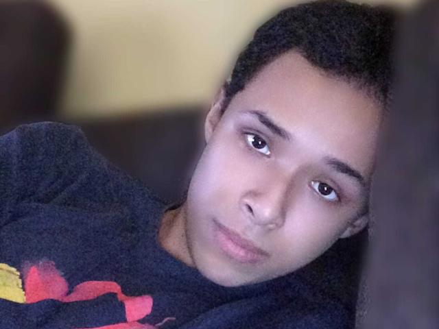 Hercolezz a un visage mignon, légèrement fatigué, avec des cheveux noirs courts, des yeux marrons et une chemise sombre avec des motifs rouges et jaunes. Elle est penchée en avant, et on dirait qu'elle est fatiguée..