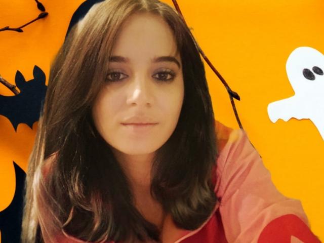 KateLaAngel ha lunghi capelli castani, un viso carino e indossa una maglietta rosa. Le sue natiche non sono visibili. Ha un adesivo a forma di fantasma sul lato destro..