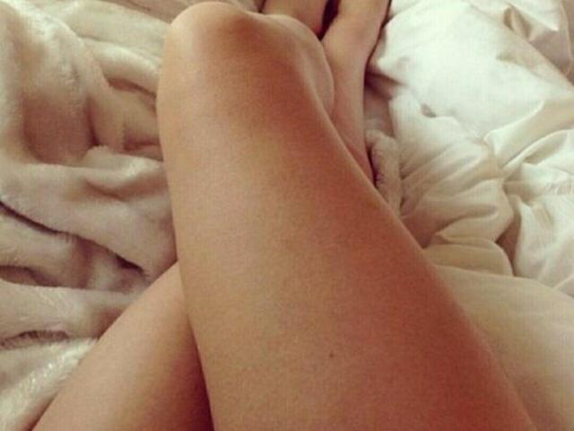 LadyMiller's legs are crossed on a white, fluffy blanket. Her smooth, light-skinned thighs and knees are in the center of the image.