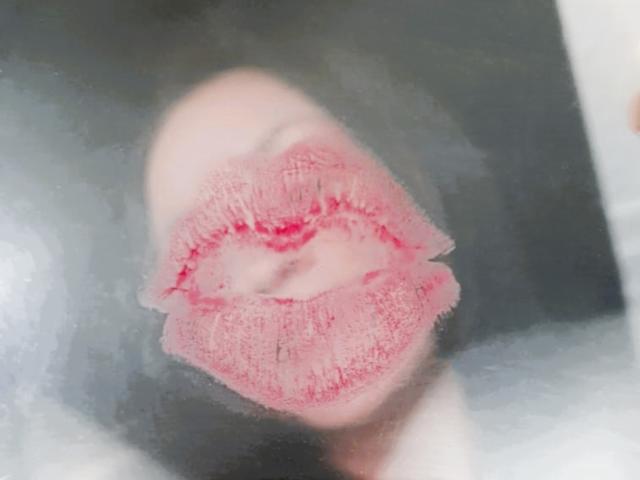 ElinaJhonson's pink, slightly smudged, full lips are centered in the image, showing detailed texture and slight redness. Her face is mostly blurred, focusing on the kiss mark.