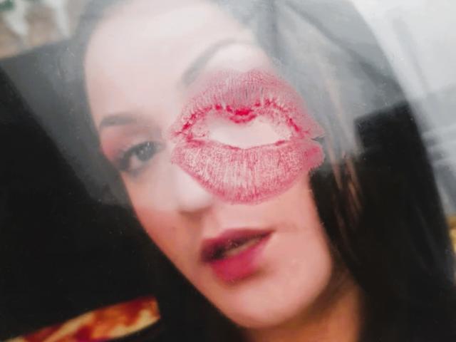ElinaJhonson's face with a red lipstick kiss mark over her mouth, dark hair, subtle makeup, and a slightly open, pink-lipped mouth. She's looking at the camera.