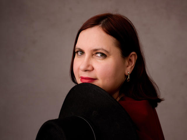 Flat, stylized design with bold, solid colors. Large, simplified letter "L" in center. Light red and pink hues. Symmetrical layout. Minimalistic, geometric. BigTitsXHot not present. Flat art style.