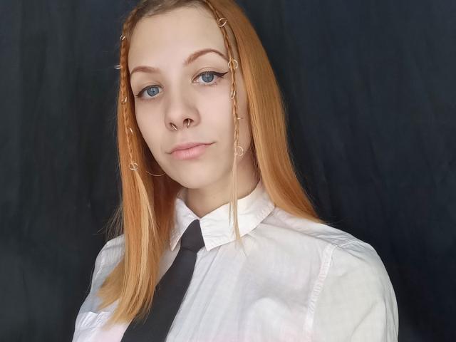 LapinaAnna a la peau pâle, les yeux bleus et les cheveux roux tressés, ornés de petites pinces dorées. Elle porte une chemise blanche et une cravate noire, et a un anneau au nez..