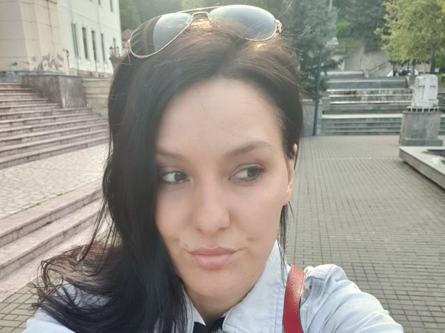 JoliDanielle's selfie shows her with dark hair, brown eyes, light skin, and subtle lipstick. She's wearing a white shirt, red strap, and sunglasses on her head.
