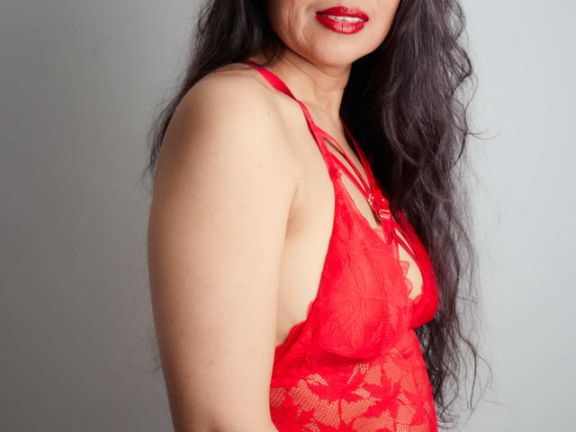 MoxiaHot with long black hair, red lace lingerie, and red lipstick, showing her red tits and side of her ass. Her skin is light, and she's smiling slightly.