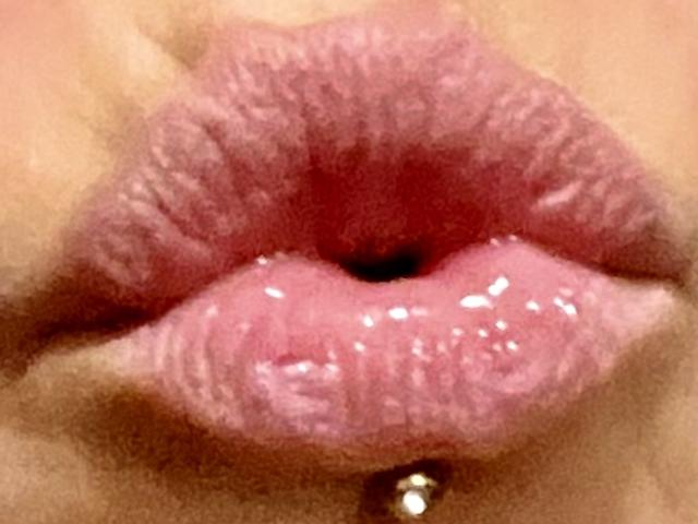 KiwiJuicy's shiny pink puffy ass-licks, with a small gold ball piercing on her lower lip, is the focus of this tight-up shot.