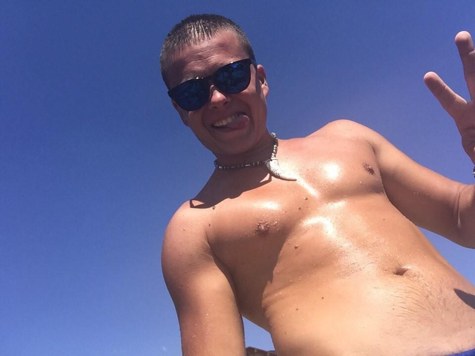 Des DustinHards brillants et transpirants, avec des cheveux bruns courts, portant des lunettes de soleil foncées et une chaîne en argent, tirant la langue, montrant leur torse nu et leur peau luisante. Ciel bleu clair..