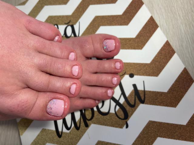 Carolina69's feet with pink and glittery pink nail polish on toes, resting on a chevron-patterned surface, showing a light skin tone and slightly pinked, polished nails.