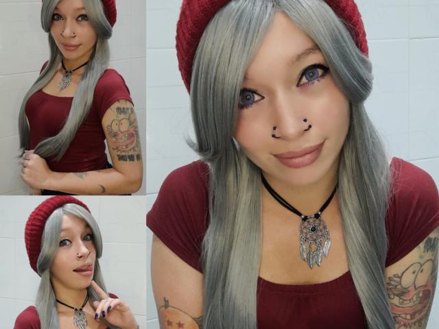 GoddessLufe a de longs cheveux gris, des yeux bleus, des piercings au nez, des tatouages, et porte un chapeau rouge et une chemise avec un collier noir. Ses seins sont petits, et ses fesses ne sont pas visibles..
