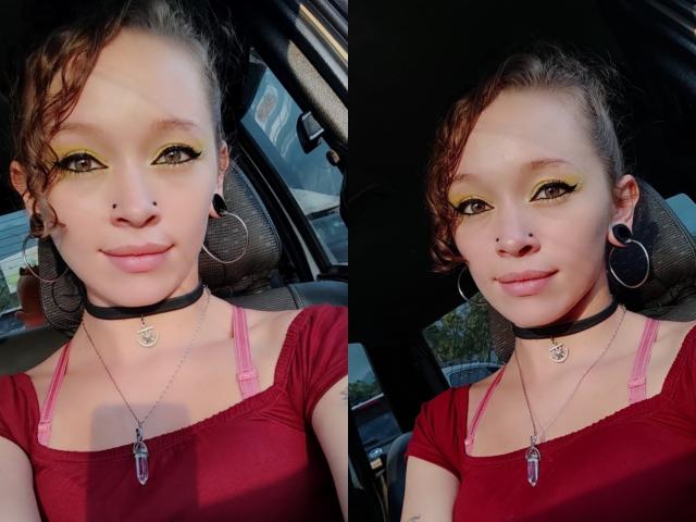 GoddessLufe mit gelbem Eyeliner, schwarzem Choker und rotem Oberteil, die kleine Nasenpiercings, schwarze Ohrringe und pinke BH-Träger zeigt, sitzt in einem Auto. Ihre Brüste sind klein..