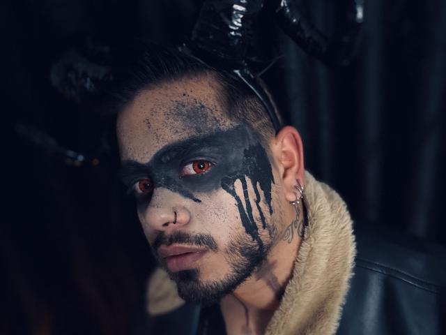 VisiI ha del trucco nero intorno agli occhi, un anello al naso e un orecchino all'orecchio sinistro. Indossa un berretto di pelle nera con corna e un colletto di pelliccia..