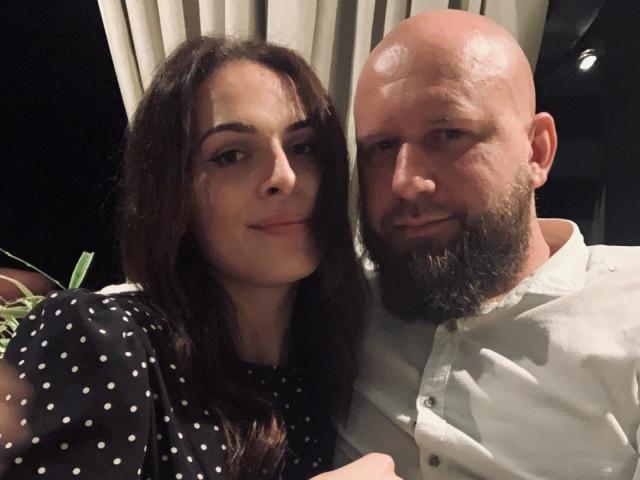 CuteReadyCpl with long brown hair and polka dot shirt, next to bald, bearded CuteReadyCpl in white shirt, both smiling. Bald CuteReadyCpl has a shiny bald head.