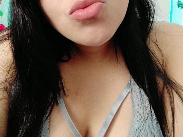 VivianaThompson has pouty pink lips and black hair, wearing a gray lace bra, showing her tits with a visible cleavage and soft skin.