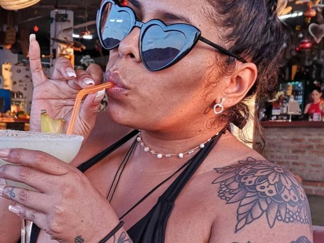 Chili sucks through an orange straw while sipping a frothy drink, her lips puckered and freckled face showing concentration.