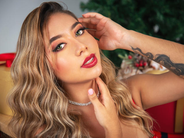 Agatha Grant heeft golvend blond haar, rode lippenstift, groene ogen en een tatoeage op haar rechterarm. Ze raakt haar kin aan met roze nagels en draagt een diamanten ketting..