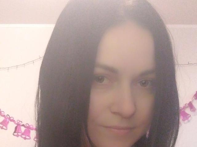 AnnaOh: Una donna con lunghi capelli neri, occhi marroni e un leggero sorriso, che guarda direttamente la fotocamera, mostrando il naso e le labbra. Il suo viso è al centro dell'immagine..