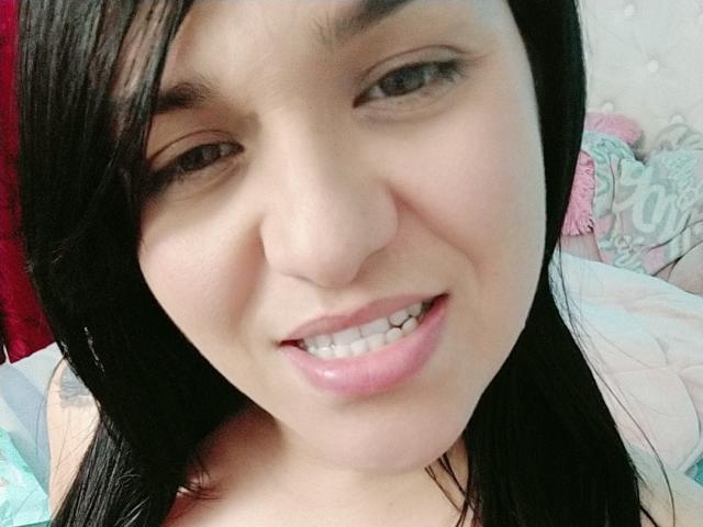Viviana Thompson tiene piel clara, ojos marrones y cabello largo y negro. Está sonriendo, mostrando labios rosados y dientes blancos. Sus pequeños senos son ligeramente visibles..