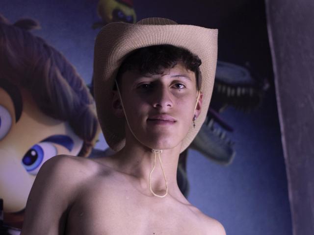 CarlosRubiio is a young dude with short brown hair, wearing a beige cowboy hat, shirtless, and a necklace. Background includes cartoonish faces and a shark.