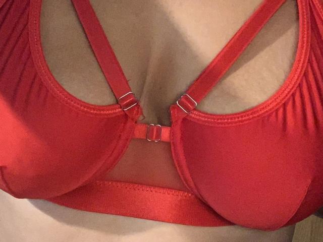 QueenKaly's red bra with metal rings is showing off her big, round tits. The bra has a sexy, supportive design with a shiny, satin-like texture.