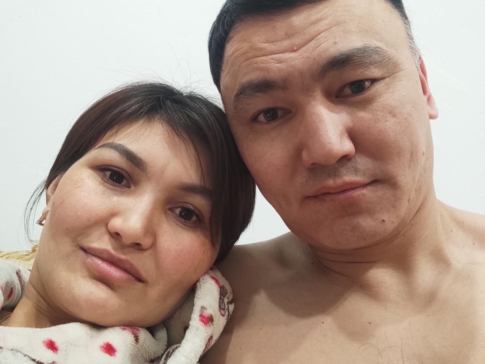 Das Gesicht von TerrieValery befindet sich nah an einem Mann ohne Hemd, beide haben einen neutralen Gesichtsausdruck, asiatische Gesichtszüge, dunkles Haar und helle Haut. TerrieValerys Wange liegt auf seiner Schulter..