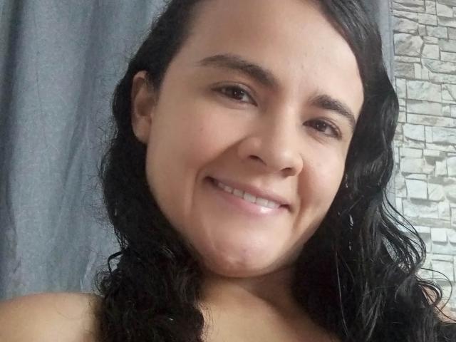 PatyHottLove tiene el pelo negro ondulado, piel de color marrón claro y está sonriendo con los labios ligeramente entreabiertos, mostrando sus dientes. Sus pechos no son visibles. Su trasero no es visible..