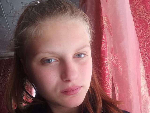 KoketaOrrie hat eine helle Haut, blaue Augen und rotes Haar, mit einem leicht ernsten Gesichtsausdruck und rosafarbenen Lippen. Ihr Hintern ist nicht sichtbar, nur ihr Gesicht..