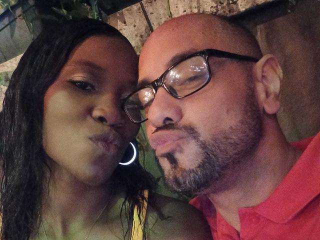 MaxAndMegan69 have puffy lips, wearing glasses, and a red shirt. MaxAndMegan69 has dark hair, hoop earrings, and a bald head with a beard. Both look serious.