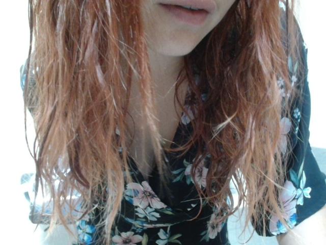 LilouLove's wet red hair, floral black top, and slightly open mouth, showing a hint of her tits, with a soft, sexy look.