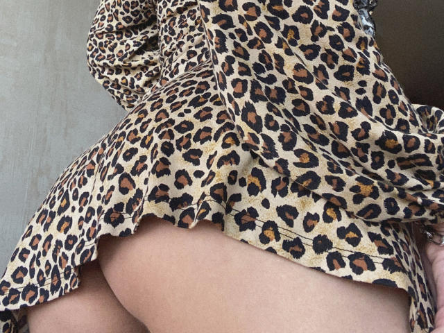 Pingli's leopard-print dress is lifted, revealing her bare, curvy ass. Her light skin contrasts with the patterned fabric. She has a soft, slightly textured body.