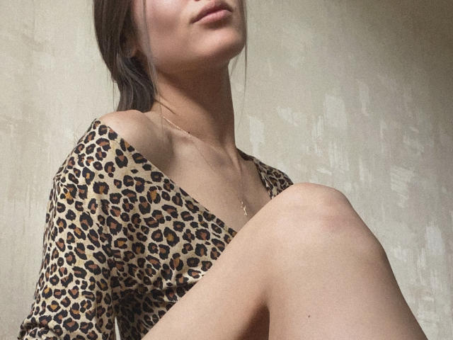 Pingli's face is partially visible, wearing a leopard print top, with her knee up, showing a slender neck and a gold necklace. Her brown hair is tied back.