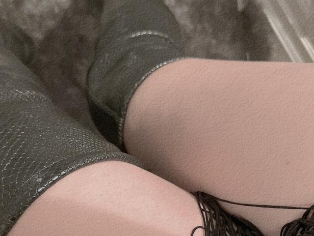 De knieën en dijen van RoseStaar zijn bedekt met groene, gestructureerde broek, met bleke huid en een zwarte draad of lint aan de onderkant. Een strak, intiem shot..