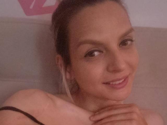 AlicePrings wearing a white ribbed crop top and light blue ribbed booty shorts, showing her flat stomach and small ass, standing with one hand on her thigh.