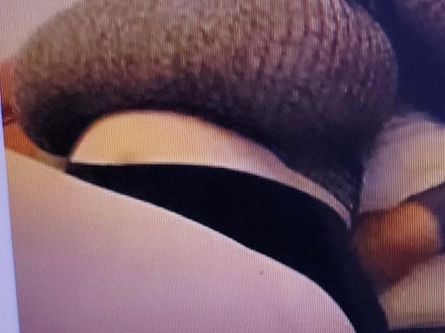 RinaBellas' butt in black panties with a hairy brown butt plug partially inserted, showing skin and fabric texture.