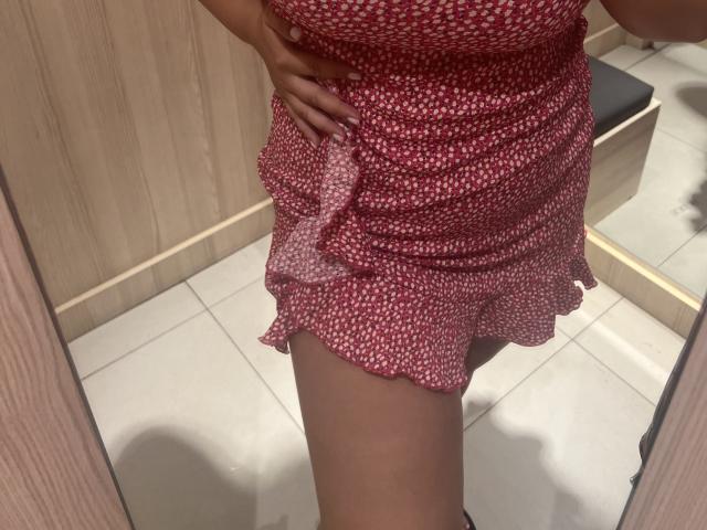 Il vestito floreale rosso e bianco di Barbarica, che mostra la sua coscia e la sua mano scoperte, con un orlo arricciato e una vita stretta, in un selfie allo specchio. Il suo sedere è parzialmente visibile..