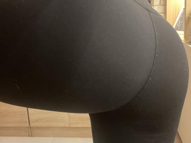 Barbarica's black, tight-ass is in the center of the image, showing a close-up of her curved, ribbed butt in black spandex. Her skin is barely visible.