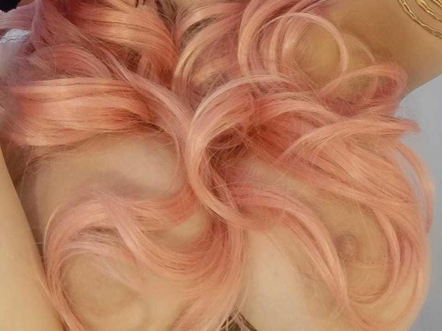 LinaStars' pink curly hair, tits barely visible, golden bracelet on right arm, soft light, wavy texture, pastel pink color, gentle curls, slightly blurred background.