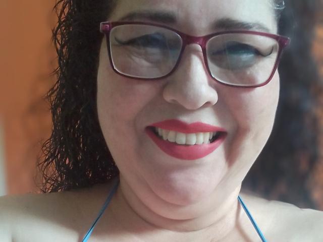 Loretta Sanchez ha i capelli neri e ricci, rossetto rosso e indossa occhiali rossi. Sorride, con le bretelle blu a halter visibili, che mostrano il suo seno. La sua pelle è chiara con un leggero rossore..
