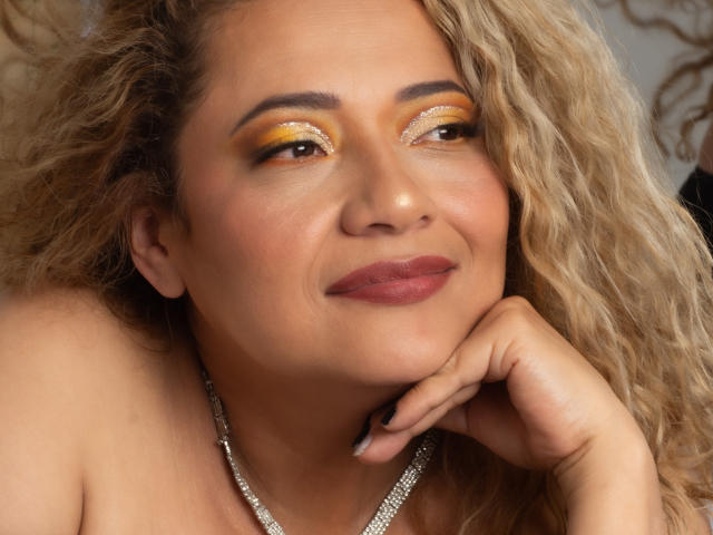 A digital art piece featuring a bold, flat-style design. Central, large letter "L" in muted red and beige. Soft shadows, simple lines, minimal texture. Light source from upper right.