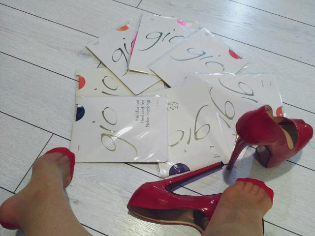 WandaDominatrix's feet in red flats, red high heels on wooden floor, and several white cards with swirling numbers scattered around. Her toes are painted red too.