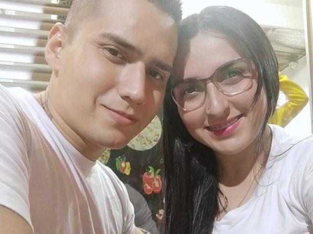 KingaNDher met kort bruin haar en een witte T-shirt, en KingaNDher met lang zwart haar, een bril en roze lippenstift, die dicht bij elkaar lachen..