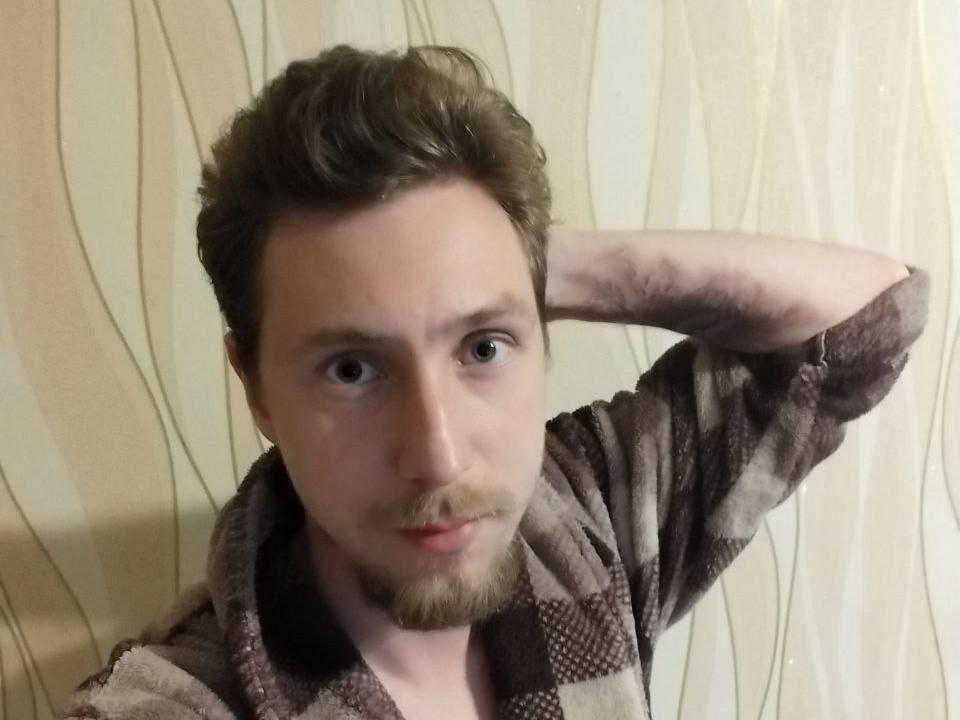 AkeshiBlade mit ernstem Gesichtsausdruck, braunen Haaren, leichtem Bart, trägt einen braun karierten Umhang, eine Hand hinter dem Kopf, blickt leicht zur Seite, blaue Augen, blasse Haut..