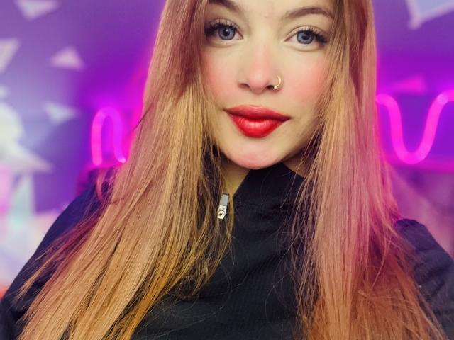ShantalSummer ha lunghi capelli di un colore rosa-arancio, occhi azzurri, rossetto rosso e un piercing al naso. Indossa una giacca nera con zip, e ha un viso carino e attraente..