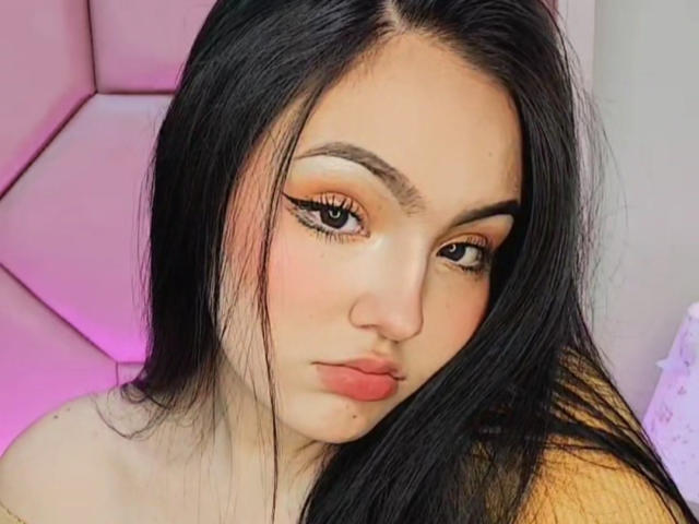 HaleiBeckham heeft lang zwart haar, oranje eyeliner en roze lippen met een fronsende uitdrukking. Haar ogen zijn lichtjes naar beneden gericht, en haar huid is bleek met een paar kleine moedervlekken..
