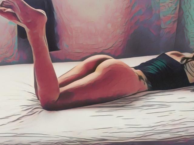 HarlyMia lying face down on a bed, legs up, showing her ass in black underwear, with pink and purple abstract patterns in the background.