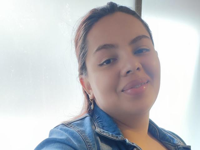 YinethBeilly, con i capelli castani, indossa una giacca di jeans, sorride alla fotocamera, mostrando un piccolo piercing al naso e un trucco leggero, appare carina e rilassata..