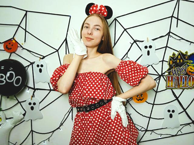 SafiraFuracao with long brown hair, red polka dot dress, off-shoulder, white gloves, black belt, Minnie Mouse ears, standing, hand on cheek, smiling, Halloween theme, cute, small tits.