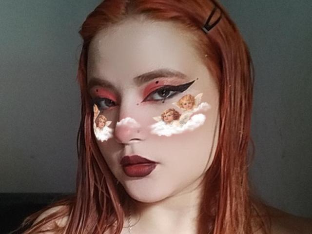 Venus: Pazzesca, con i capelli rossi, l'eyeliner nero, l'ombretto rosso, piccoli angioletti sulle guance, rossetto scuro e una molletta nera tra i capelli. Il suo viso è pallido..