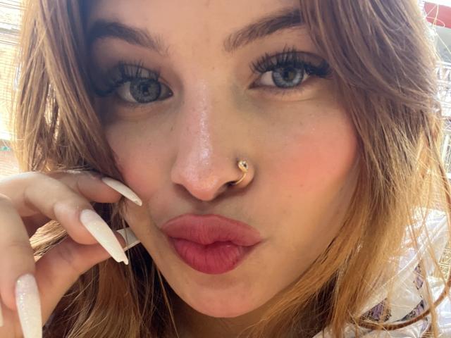 ShantalSummer tiene el cabello largo y castaño, ojos azules, y lleva un piercing en la nariz con una pequeña bola dorada. Sus labios rosados están fruncidos, y tiene las uñas largas y blancas..